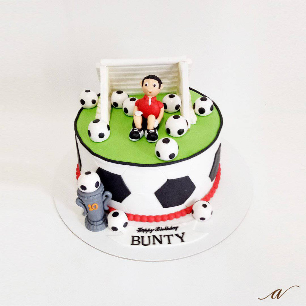 Closeup Image Of Football Themed Layered Birthday Cake Decorated On Cake  Board With Black And White Hexagonal Shaped Fondant Icing Tessellating  Tiles With Red Background Soccer Balls And Blades Of Green Grass